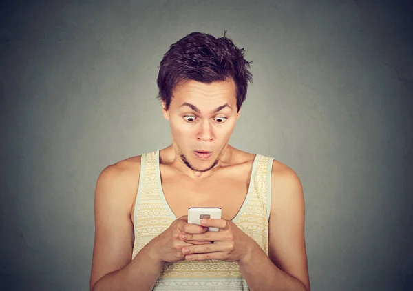 Шокированный человек, читающий смс или новости на мобильном телефоне — стоковое фото