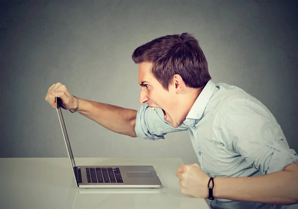 Ondernemer boos en woedend met een laptop in zijn kantoor — Stockfoto