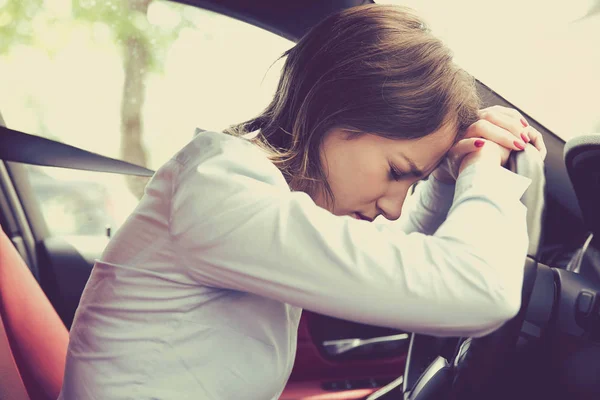 Stressed woman driver sitting inside her car