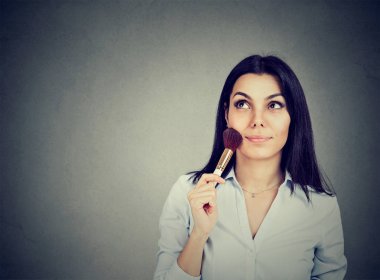 Makyaj fırça ile düşünceli kadın