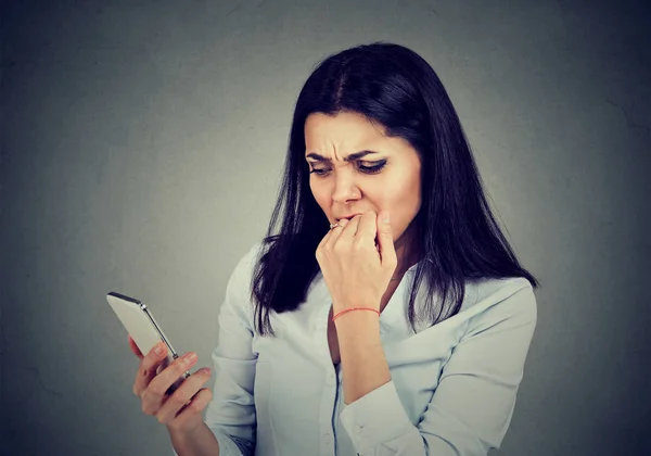 Сердитая беспокойная женщина смотрит приложения в мобильном телефоне — стоковое фото