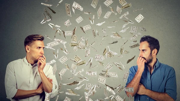 Side profile businessmen looking at each other with money rain in-between — Stock Photo, Image