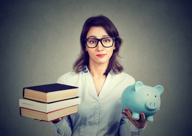 woman with stack of books and piggy bank full of debt rethinking career path  clipart