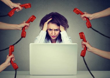 Çok fazla telefon çağrıları tarafından bunalmış bir dizüstü bilgisayar üzerinde çalışan iş kadın vurguladı