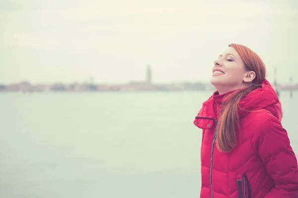 Mulher sorrindo olhando para o céu desfrutando de liberdade em uma cidade de fundo de Veneza Itália — Fotografia de Stock