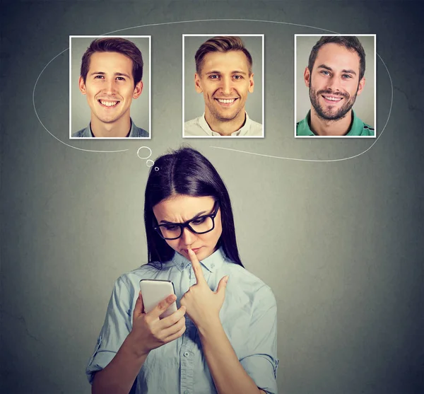 Mujer reflexiva pensando qué hombre le gusta la mayoría de uso de la aplicación de teléfono inteligente — Foto de Stock