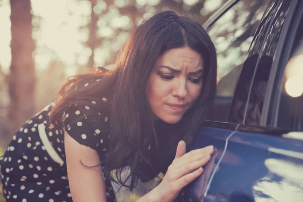 Worried funny looking woman obsessing about cleanliness of her car — Stock Photo, Image