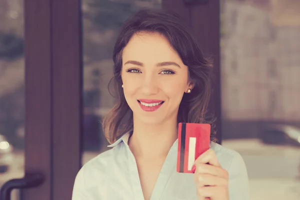 Alegre sonrisa dentada mujer sosteniendo mostrando tarjeta de lealtad cerca del centro comercial tienda al aire libre en la calle . — Foto de Stock