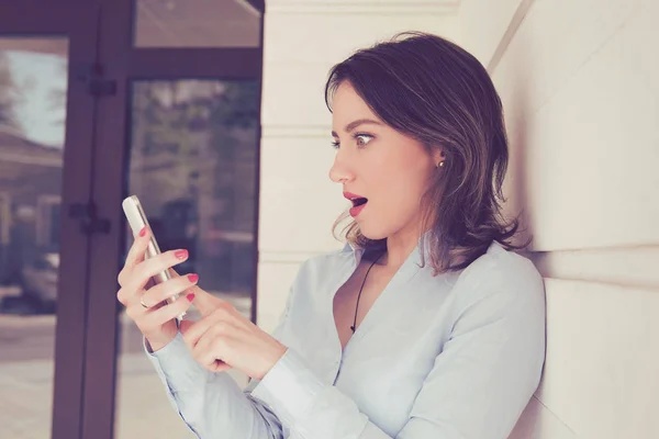 Surprised woman looking at phone seeing unexpected news or photos — Stock Photo, Image