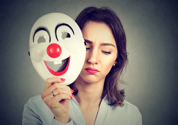 Traurige Frau legt fröhliche Clownsmaske ab — Stockfoto