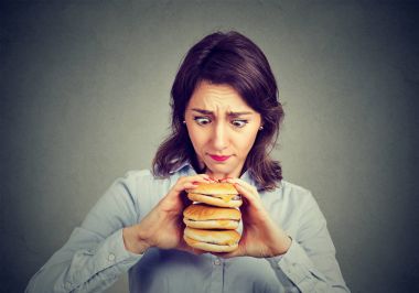 Özlem lezzetli üç hamburger yiyen Kadın 