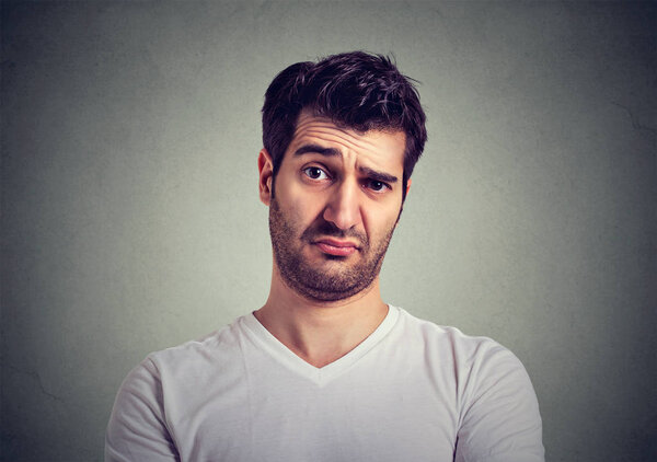 Нахмурившись, молодой человек думает, выражая сомнения и опасения
