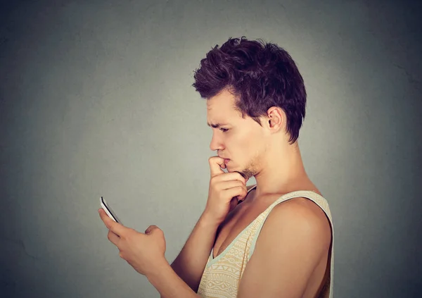 Hombre mirando confundido a su teléfono móvil —  Fotos de Stock