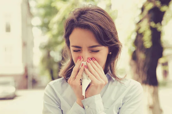 Woman with allergy symptoms blowing nose — Stock Photo, Image
