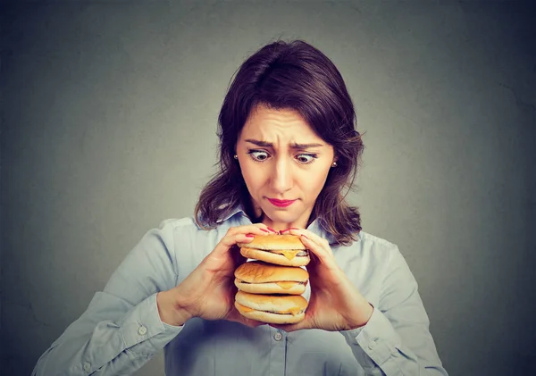 Mujer comiendo ansia de una sabrosa hamburguesa triple —  Fotos de Stock