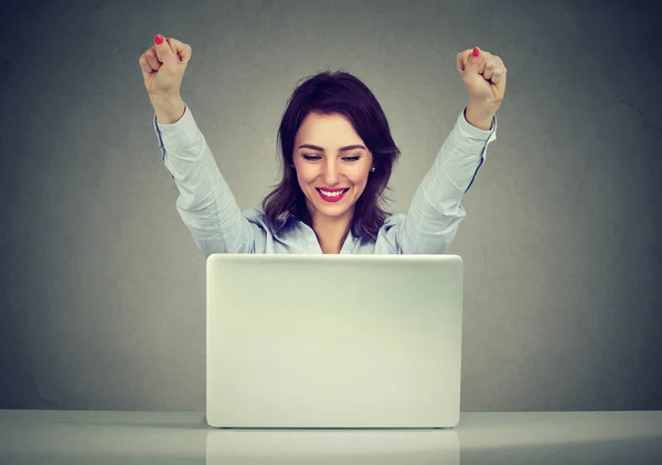 Succesvolle vrouw winnaar met armen verhoogd kijken naar laptop — Stockfoto