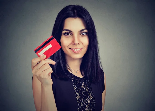 Happy woman showing credit card isolated on gray background — Stock Photo, Image