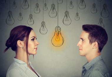 Cognitive skills ability concept, male vs female. Man and woman looking at bright light bulb  clipart