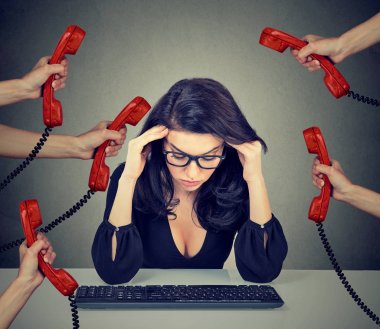 Çok fazla telefon çağrıları tarafından bunalmış bilgisayarda çalışan iş kadın vurguladı