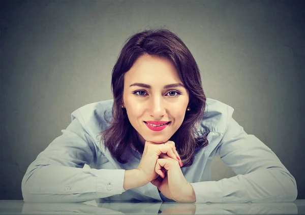 Happy woman leaning at table smiling at camera — Stock Photo, Image