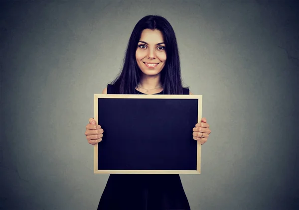 Sorrindo mulher segurando um quadro com copyspace . — Fotografia de Stock