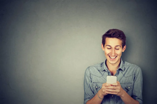 Guapo feliz chico usando un teléfono inteligente — Foto de Stock