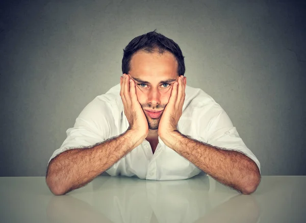 Triste hombre aburrido sentado a la mesa en su oficina — Foto de Stock