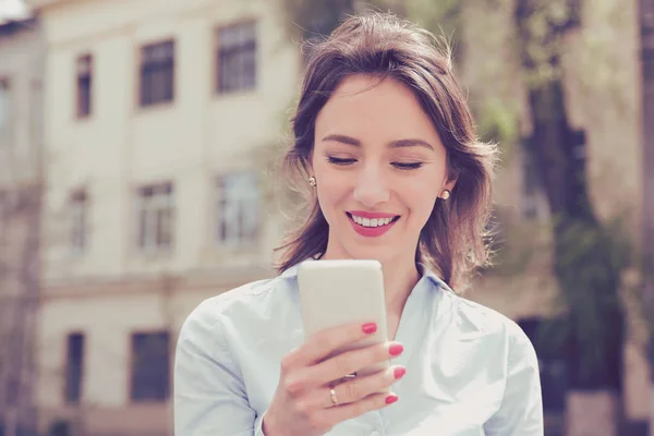 Mooie vrouw met behulp van haar mobiele telefoon in de straat. — Stockfoto