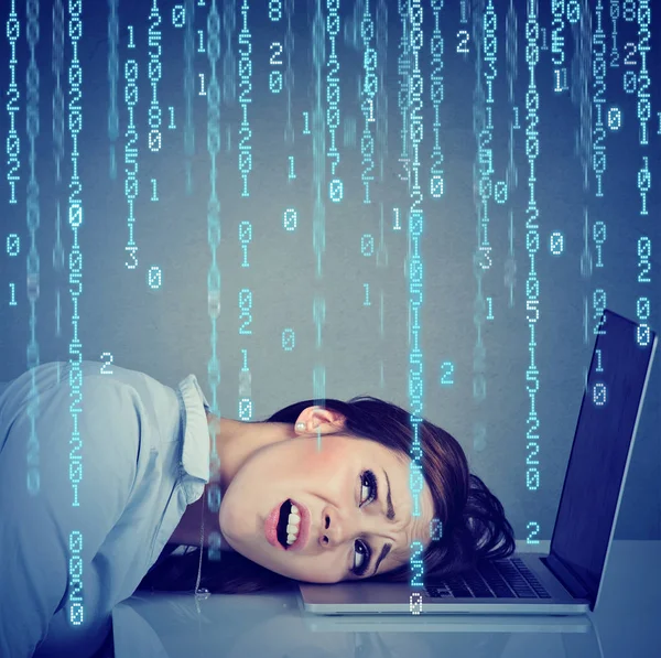 Mujer estresada desesperada descansando cabeza en el ordenador portátil con código binario cayendo —  Fotos de Stock