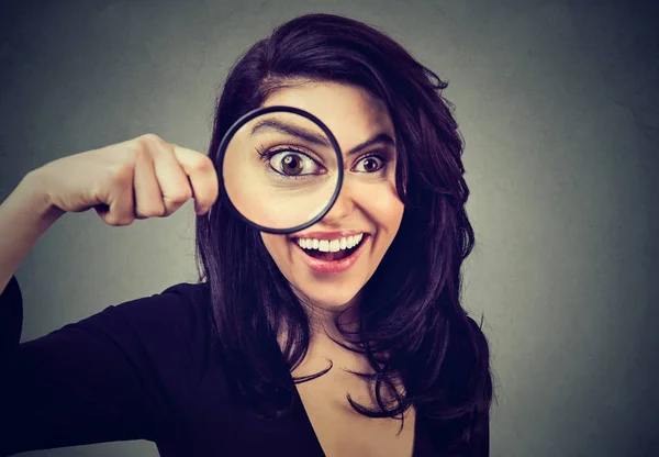 Curious surprised young woman looking through a magnifying glass — Stock Photo, Image