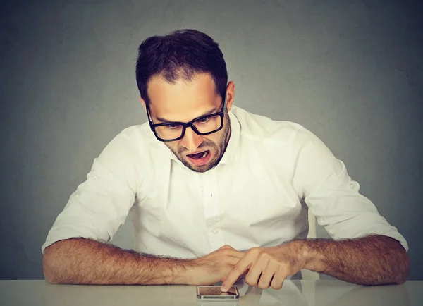 Boos boos jongeman met zijn smartphone — Stockfoto