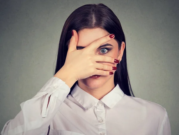 Rädd ung kvinna kikar genom hennes fingrar — Stockfoto