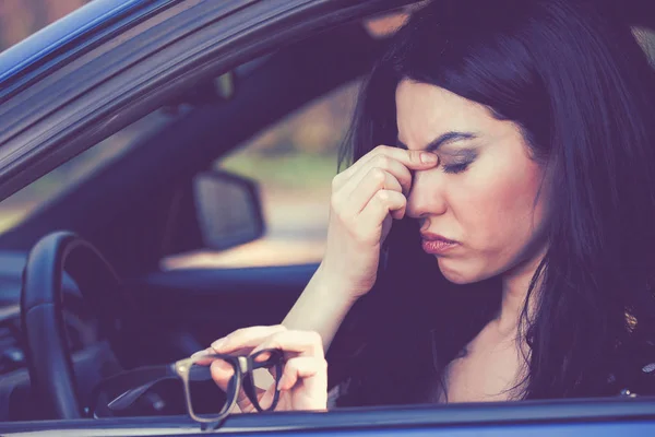 Business woman having headache taking off her glasses has to make a stop after driving car on rush hour. — Stock Photo, Image