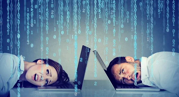 Podkreślił biznes kobieta i mężczyzna odpoczynek głowę na laptopie pod deszcz kod binarny, siedząc przy stole — Zdjęcie stockowe