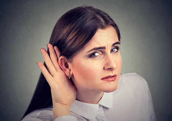 Mujer con pérdida de audición tapando la mano detrás de la oreja para tratar de amplificar el sonido disponible — Foto de Stock