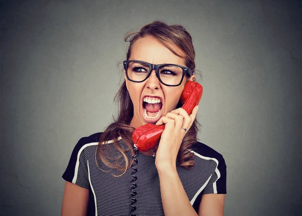 Young woman yelling on the red phone — Stock Photo, Image