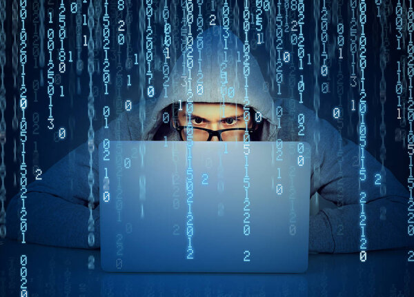 Man hacker working on a laptop on binary code background 