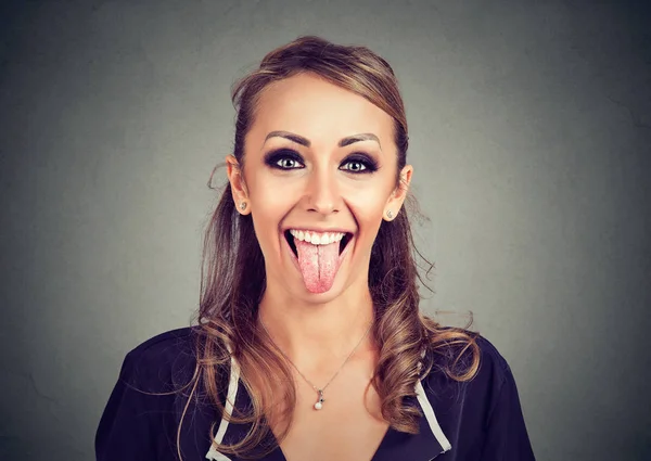 Retrato de una joven mujer de aspecto divertido mostrando su lengua — Foto de Stock