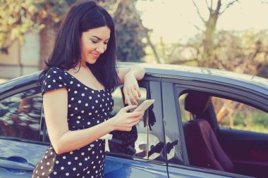 Onun araba manifatura üstünde hareket eden telefon tarafından duran başarılı genç kadın 