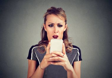 Kötü haber fotoğraf iletisi iğrenç duygu ile yüzünü görüyor telefon bakarak komik şok korkmuş kadın 