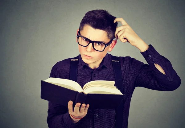 Hombre confundido en gafas perplejo después de leer un libro — Foto de Stock