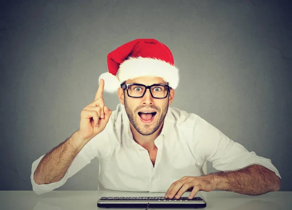 Happy christmas man in red santa claus hat buying stuff online. Holiday xmas shopping — Stock Photo, Image