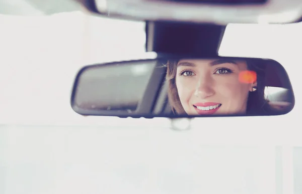 Wesoły kobieta jazdy samochodu, widok z tyłu, reflexion twarz w lustrze — Zdjęcie stockowe