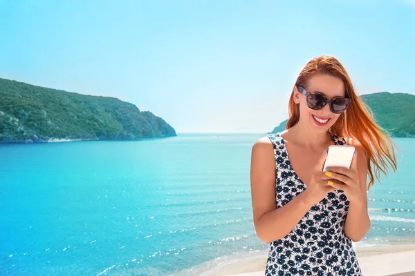 Beautiful happy woman using a smart phone on a balcony of a vill — Stock Photo, Image