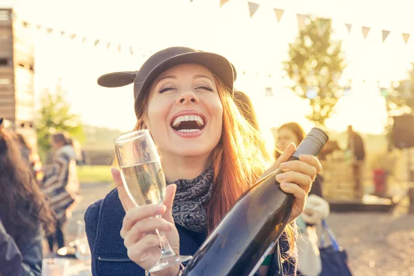 Happy young woman drinking wine having fun outdoors