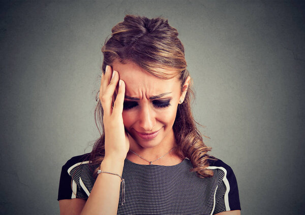 Отчаянная молодая женщина плачет, глядя вниз
