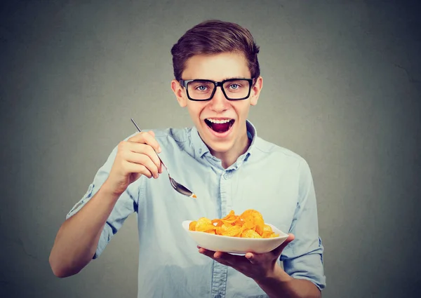 Joven hombre divertido teniendo un plato de papas fritas — Foto de Stock