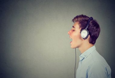Müzik ve şarkı mavi gömlekli kulaklıklarla yakışıklı adam  