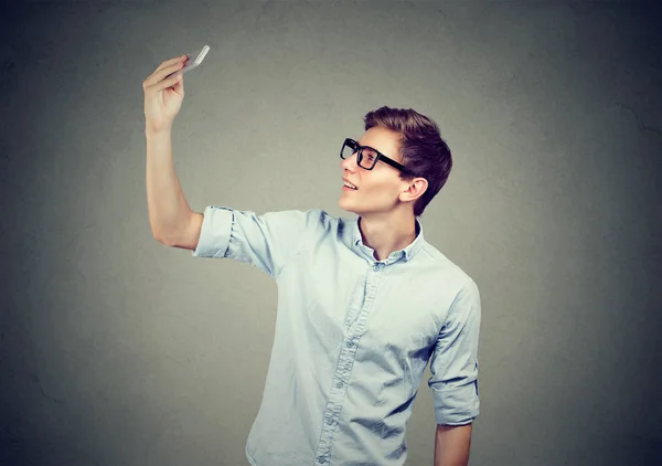 Young man taking pictures of himself with smart phone — Stock Photo, Image