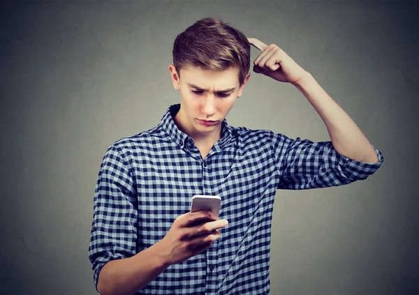 Ung man förstummad om vad han ser på mobiltelefon, söker lösning — Stockfoto